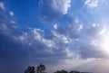 Sun hiding behind clouds, sunrays shining in daylight sky background, nature photography, natural scenic wallpaper