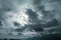 Sun hiding behind the dark black clouds over the blue sky, dramatic sky, atmospheric moods and bad weather background Royalty Free Stock Photo