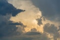 Sun hiding behind dramatic clouds during moody cloudy sunset, copy space, peaceful meditation