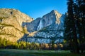 Sun hitting cliffs at Upper Yosemite Falls from valley floor Royalty Free Stock Photo