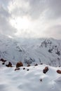 The sun illuminates snow mountains. Clouds close the sky Royalty Free Stock Photo