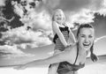 Cheerful healthy mother and child on seashore having fun time