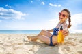 Smiling fit woman in beachwear on the seashore with sun cream Royalty Free Stock Photo