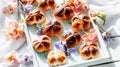 Sun-Kissed Hot Cross Buns with Spring Flowers on Rustic Wooden Tray. Royalty Free Stock Photo