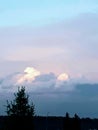 The sunlight kissing the tops of the huge dark storm clouds