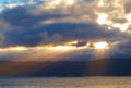 Sun light breaking through dark cloudy copyspace over a calm ocean. Sunlight shining through thick clouds in the early