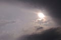 The sun looks out from behind the clouds before a thunderstorm. Dark gray heavy stormy sky. Dramatic impressive illustration on Royalty Free Stock Photo