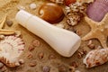 Sun lotion and Different seashells on the beach sand. Summer background. Royalty Free Stock Photo