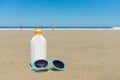 Sun lotion and sunglasses in the beach Royalty Free Stock Photo
