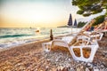 Sun loungers and beach umbrellas at sunset on the beach of Gradac in Makarska riviera