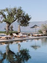 Sun loungers with mattresses and sun umbrellas stand by the pool. Hotel Amanzoe, Greece Royalty Free Stock Photo