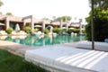 Sun loungers near outdoor swimming pool, blurred view. Luxury resort