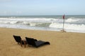 Sun loungers by rough sea