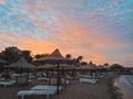 Sun loungers and straw umbrellas and beautiful sunset on the beach of Hurghada, Egypt Royalty Free Stock Photo