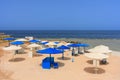 Sun loungers with umbrellas on the beach in Marsa Alam at sunrise, Egypt Royalty Free Stock Photo