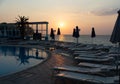 Sun lounges overlooking infinity pool and beach at sunset in a resort. Rhodes