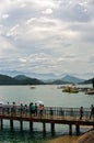 The Sun Moon Lake in Taiwan with boats on the water surface and people on the bridge
