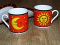 The sun and the moon on two fine porcelain ware tea coffee cups. Royalty Free Stock Photo