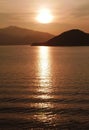 Sun, mountain, ocean and water wave at sunset Royalty Free Stock Photo
