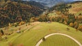 Sun mountain road aerial. Autumn nobody nature landscape. Village at mist haze. Countryside forest