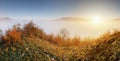 Sun over clouds mist in mountain landcape at sunrise