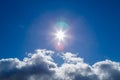 sun over white cloud on blue sky background with natural lens flares Royalty Free Stock Photo