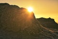 Sun peaking over a rock at winter solstice Royalty Free Stock Photo