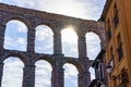 Sun peeking out between the arches of the Roman aqueduct of Segovia, Spain. Royalty Free Stock Photo