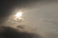 The sun peeks out from behind the clouds after a thunderstorm. Dark gray heavy stormy sky. Dramatic impressive illustration on the Royalty Free Stock Photo