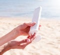 Sun protection cosmetics. Caucasian woman applying sun cream sunbathing on beach Royalty Free Stock Photo