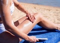 Sun protection cosmetics. Caucasian woman applying sun cream sunbathing on beach Royalty Free Stock Photo