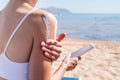 Sun protection cosmetics. Caucasian woman applying sun cream sunbathing on beach Royalty Free Stock Photo