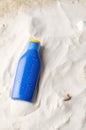 Sun protection. Cream, tanning lotion, anti-tanning. Blue plastic bottle on sand