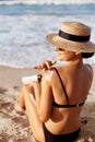 Sun Protection, girl using sunscreen to safe her skin healthy. Sexy young woman in bikini holding  bottles of sunscreen in her han Royalty Free Stock Photo
