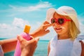 Mother put sunblock cream on little daughter face at beach