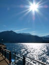 View over the glittering lake to the mountain with a radiant sun