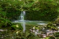 Sun ray lights over a small waterfall in a river in Galdames, Basque Country