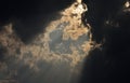 Sun ray penetrates through the dark cloud in the evening sky. Royalty Free Stock Photo