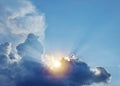 The sun and sun rays appearing from behind a great fluffy cloud Royalty Free Stock Photo