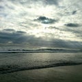 Sun rays on beach rolling waves horizon line