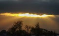Sun rays beaming through a dark cloud Royalty Free Stock Photo