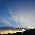 Sun rays through beautiful clouds at sunset Royalty Free Stock Photo