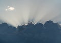 Sun rays from behind clouds on blue sky Royalty Free Stock Photo