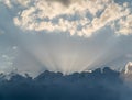 Sun rays from behind clouds on blue sky Royalty Free Stock Photo