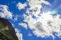 Sun rays and blue sky behind white clouds, Norway Royalty Free Stock Photo