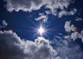 Sun rays with blue sky surrounded by clouds Royalty Free Stock Photo