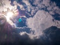 Sun with rays in the blue sky and thick clouds Royalty Free Stock Photo