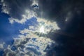 The sun rays break through a thundercloud on a blue sky. Royalty Free Stock Photo