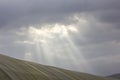 Sun rays breaking through the clouds over a mountain landscape