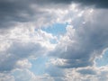 Sun rays breaking through a large cloud formed in the sky surrounded by diffuse clouds